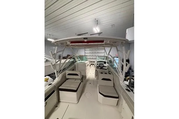 Slide: The Image of 2022 Sailfish 245 DC boat interior with seating and helm in a storage facility. - 8