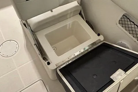 Slide: The Image of 2022 Sailfish 245 DC boat interior with open storage compartment and seating. - 9