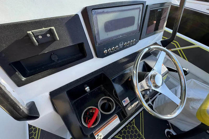 Slide: The Image of 2022 Scarab 255 Open ID boat dashboard with steering wheel and control panel. - 13