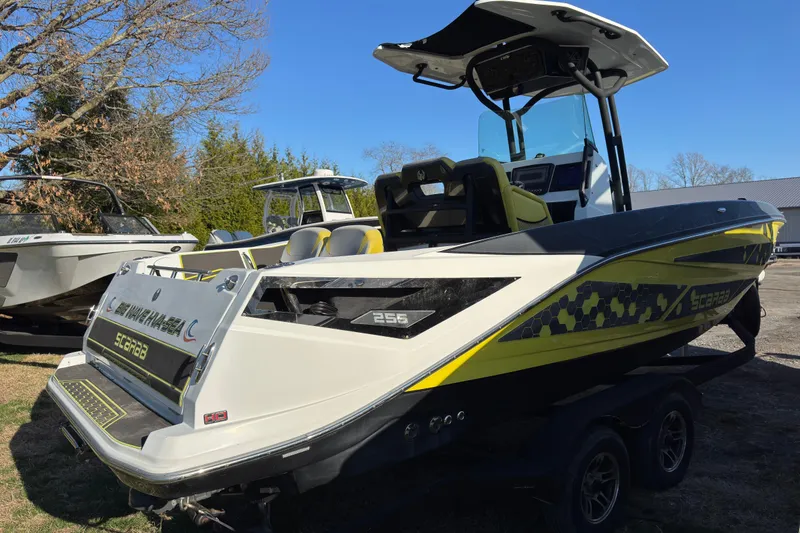 Slide: The Image of 2022 Scarab 255 Open ID boat with vibrant yellow accents on display outdoors. - 2