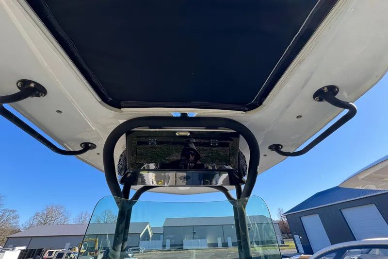 Slide: The Image of 2022 Scarab 255 Open ID boat interior with T-top and windshield, outdoor setting. - 7