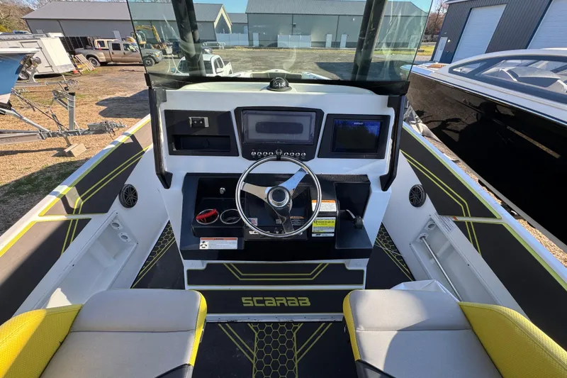 Slide: The Image of 2022 Scarab 255 Open ID boat dashboard with steering wheel and controls. - 8