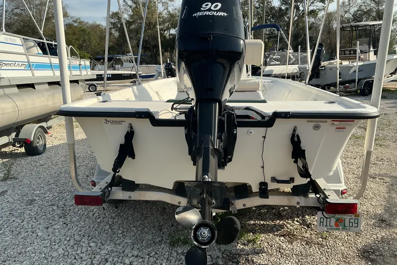 Slide: The Image of 2010 Mako 181 Inshore boat with Mercury 90 engine, parked on gravel. - 3