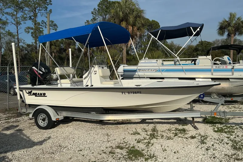 Slide: The Image of 2010 Mako 181 Inshore boat with blue canopy on trailer, parked outdoors. - 5
