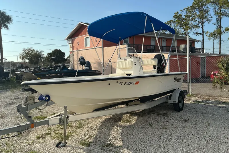 Slide: The Image of 2010 Mako 181 Inshore boat with blue canopy on trailer, parked outdoors. - 6
