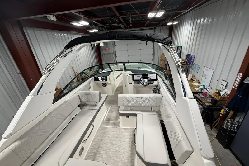 Slide: The Image of 2026 Sea Ray SDX 270 boat interior in a garage, showcasing seating and helm. - 11
