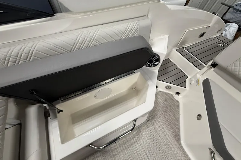 Slide: The Image of 2026 Sea Ray SDX 270 boat interior with open storage compartment and cushioned seating. - 15