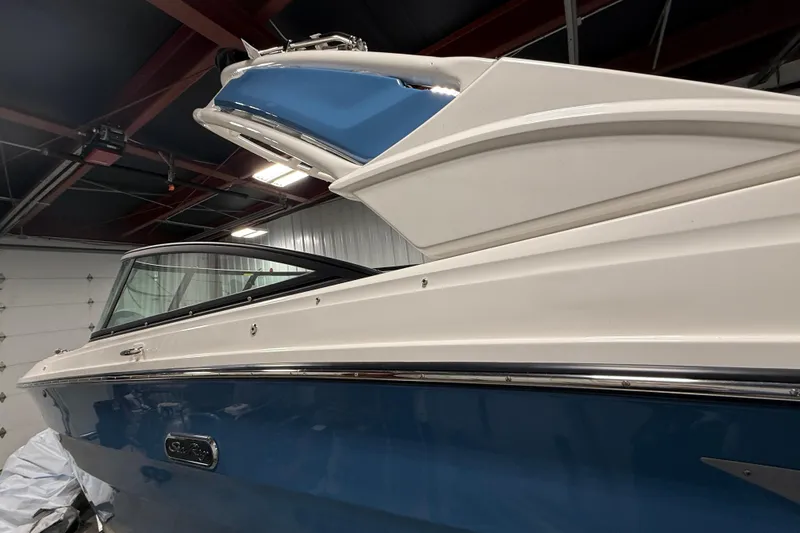 Slide: The Image of 2026 Sea Ray SDX 270 boat in a garage, showcasing sleek design and blue hull. - 2