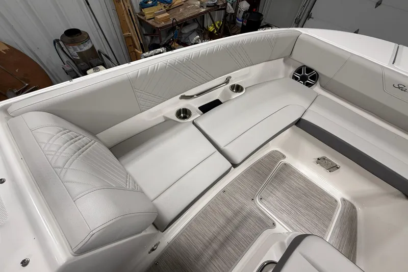 Slide: The Image of 2026 Sea Ray SDX 270 boat interior with white seating and cup holders. - 23