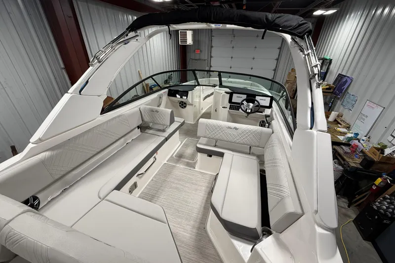Slide: The Image of 2026 Sea Ray SDX 270 boat interior with luxurious seating and modern dashboard in a garage setting. - 28