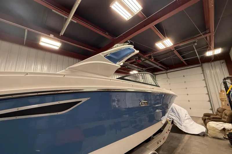 Slide: The Image of 2026 Sea Ray SDX 270 boat in a garage, blue and white exterior. - 4