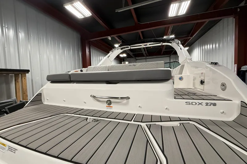 Slide: The Image of 2026 Sea Ray SDX 270 boat in a showroom, showcasing sleek design and spacious deck. - 5