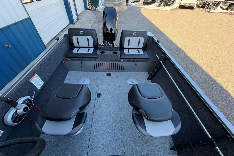 Slide: The Image of 2026 Crestliner 1650 Kodiak boat interior with seating and motor, docked outdoors. - 15