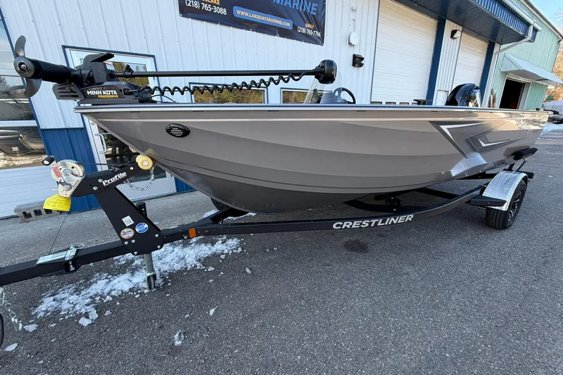 Slide: The Image of 2026 Crestliner 1650 Kodiak boat on trailer, parked outside a marine shop. - 6