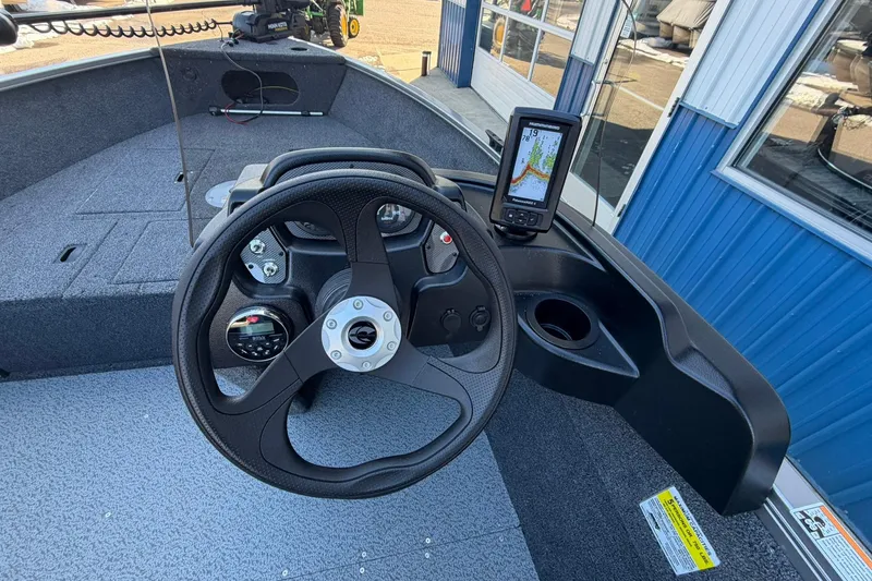 Slide: The Image of 2026 Crestliner 1650 Kodiak boat dashboard with steering wheel and navigation display. - 9