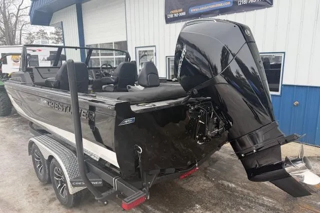 Slide: The Image of 2026 Crestliner 2050 Fish Hawk boat with powerful outboard motor, parked on a trailer. - 3