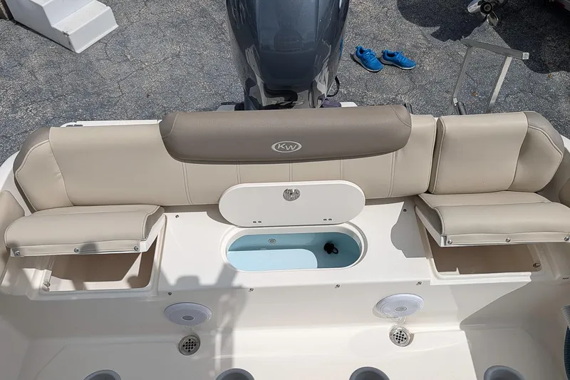Slide: The Image of 2022 Key West 219 FS boat interior with beige seating and storage compartments. - 8
