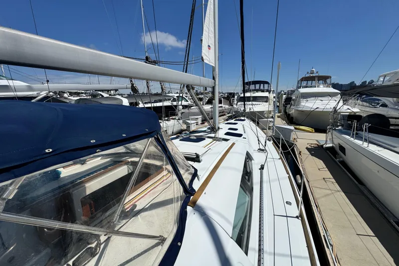 Slide: The Image of 2008 Beneteau 49 sailboat docked at marina, surrounded by other yachts under clear blue sky. - 10