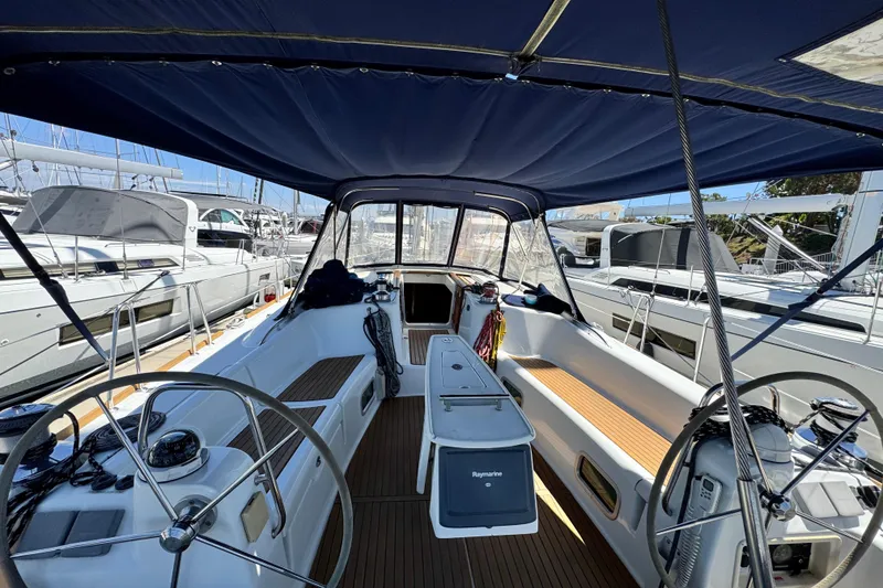 Slide: The Image of 2008 Beneteau 49 sailboat cockpit with dual steering wheels and covered seating area. - 20
