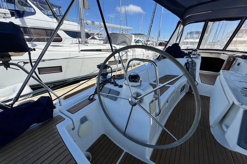 Slide: The Image of Cockpit of 2008 Beneteau 49 yacht with steering wheel and marina view. - 21