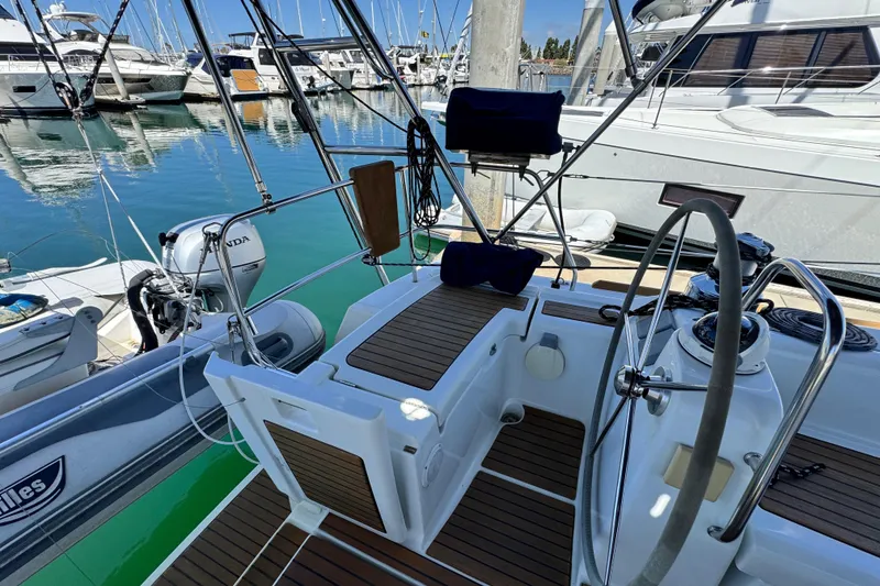 Slide: The Image of 2008 Beneteau 49 sailboat cockpit with steering wheel, docked at marina. - 25