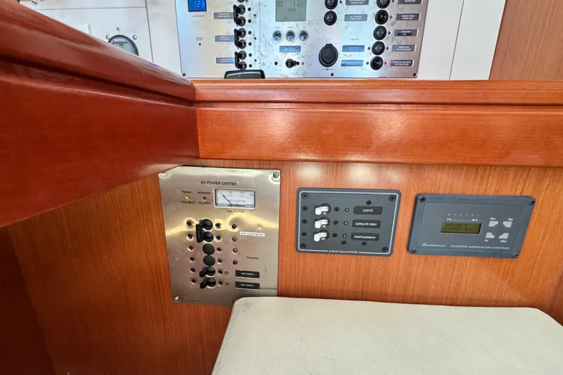 Slide: The Image of Control panel of a 2008 Beneteau 49 yacht, featuring AC power and generator controls. - 32