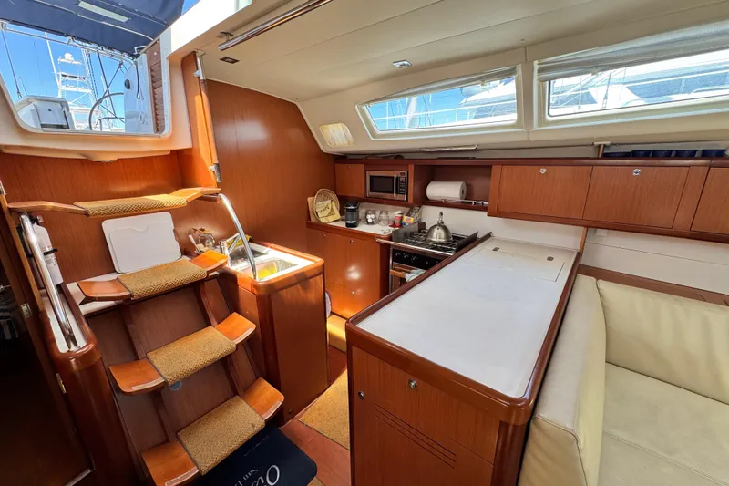 Slide: The Image of Interior of a 2008 Beneteau 49 yacht with wooden cabinetry and modern kitchen amenities. - 34