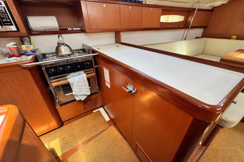 Slide: The Image of Cozy kitchen area in a 2008 Beneteau 49 yacht with wooden cabinetry and stove. - 39
