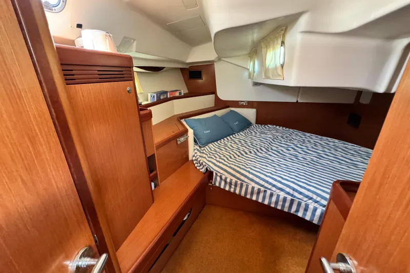 Slide: The Image of Cozy cabin interior of 2008 Beneteau 49 yacht with striped bedding and wooden furnishings. - 41