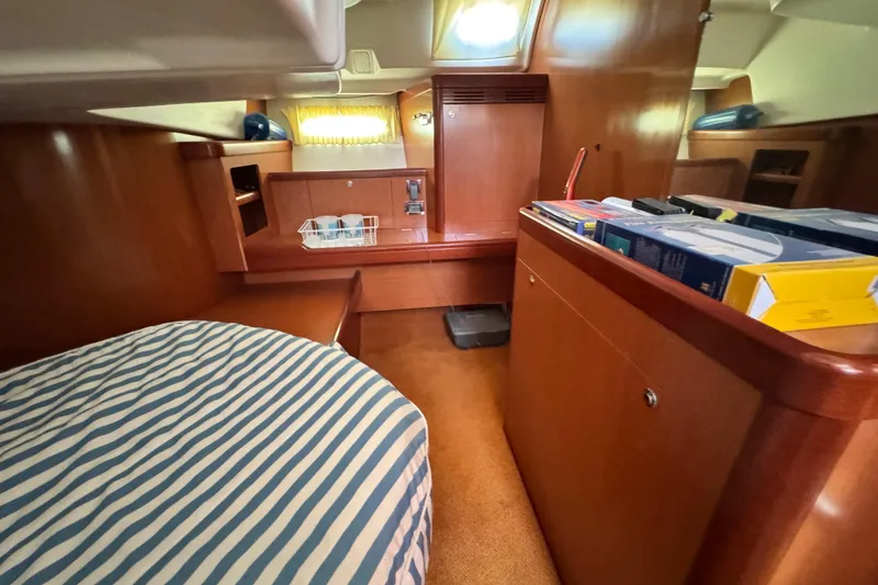 Slide: The Image of Interior of 2008 Beneteau 49 yacht with wood finish and striped bedding. - 43