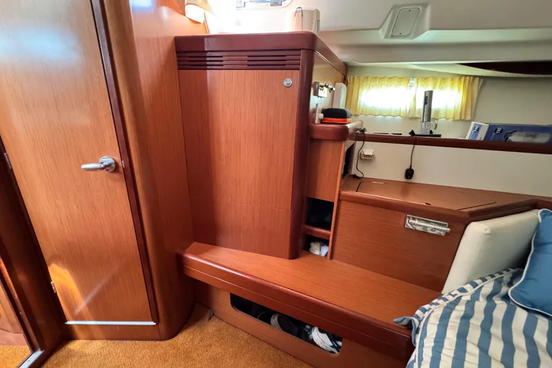 Slide: The Image of Interior of 2008 Beneteau 49 yacht with wooden cabinetry and striped cushions. - 44