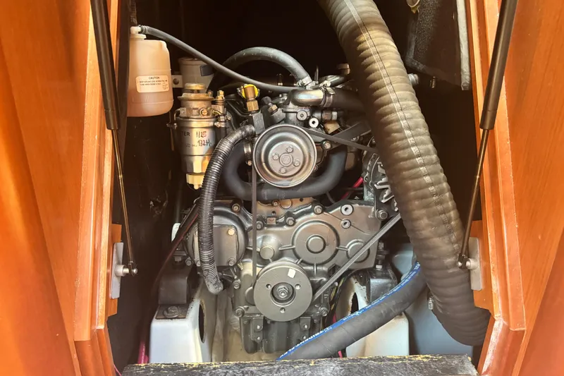 Slide: The Image of Engine compartment of a 2008 Beneteau 49 sailboat, showcasing mechanical components and hoses. - 46
