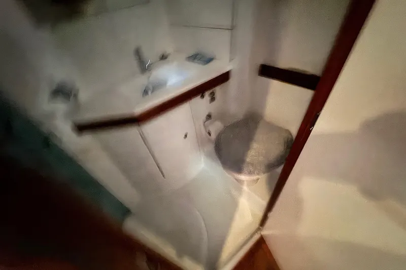 Slide: The Image of Bathroom interior of a 2008 Beneteau 49 yacht, featuring a compact sink and toilet. - 52
