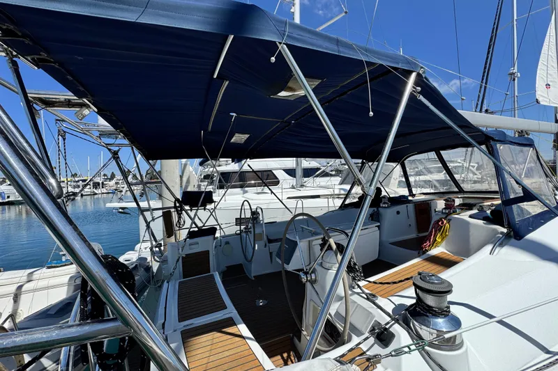 Slide: The Image of 2008 Beneteau 49 sailboat cockpit with dual steering wheels and blue canopy at marina. - 8