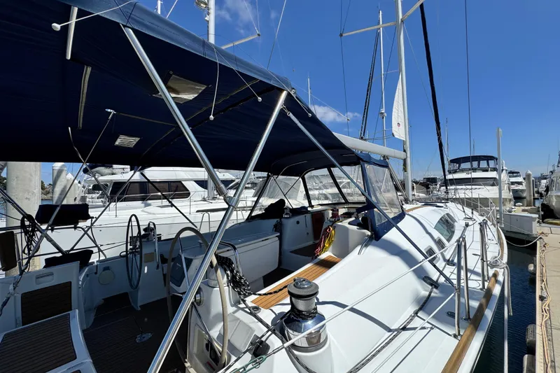 Slide: The Image of 2008 Beneteau 49 sailboat docked at marina, featuring spacious deck and dual steering wheels. - 9