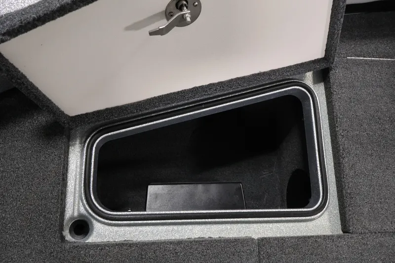 Slide: The Image of Open storage compartment in 2022 Ranger 1880MS boat, featuring secure latch and carpeted interior. - 17