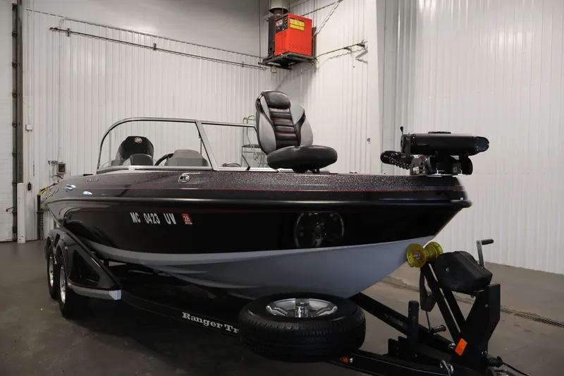 Slide: The Image of 2022 Ranger 1880MS boat in a garage, black exterior, on a trailer. - 2