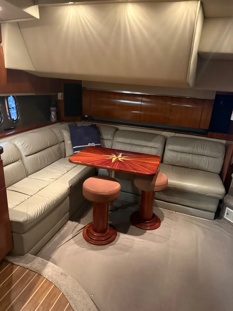 Slide: The Image of Interior of 2006 Cruisers Yachts 420 Express with leather sofa and wooden table. - 2