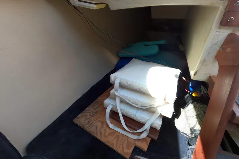 Slide: The Image of Interior storage space of a 1983 Catalina 25 sailboat with cushions and gear. - 10