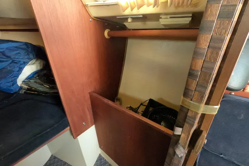 Slide: The Image of Interior of a 1983 Catalina 25 sailboat showing wooden cabinetry and storage area. - 14