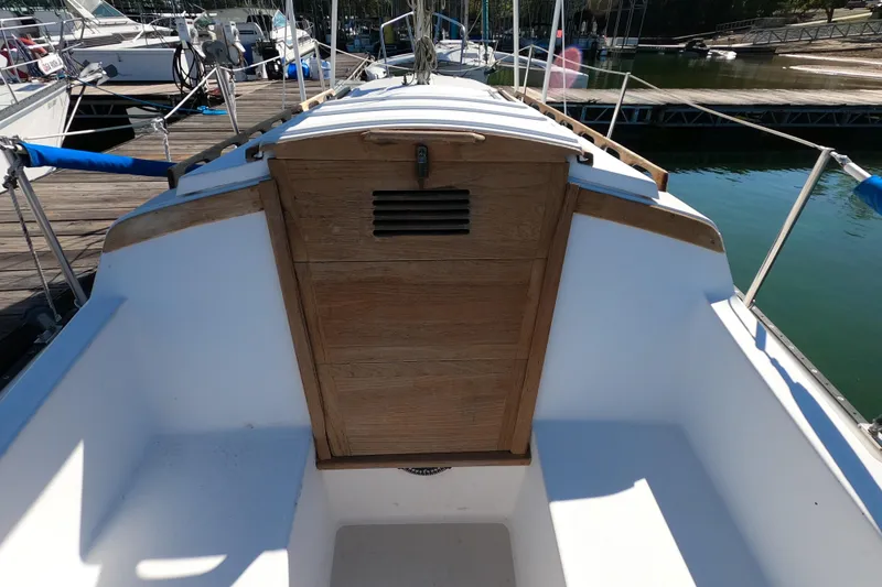Slide: The Image of 1983 Catalina 25 sailboat cockpit with wooden hatch, docked at marina. - 18
