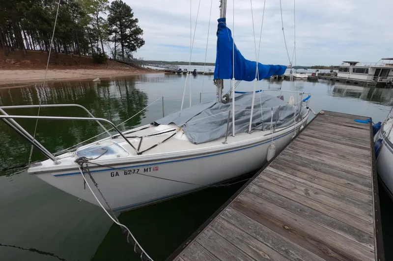Slide: The Image of 1983 Catalina 25 sailboat docked at a marina with blue sail cover. - 3