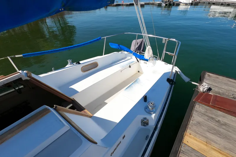 Slide: The Image of 1983 Catalina 25 sailboat docked, featuring a clean deck and blue accents. - 4