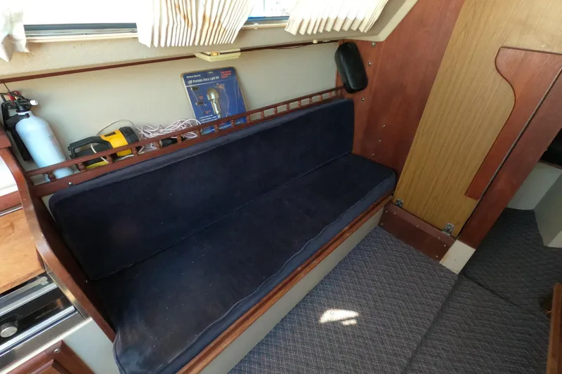 Slide: The Image of Interior of a 1983 Catalina 25 sailboat with a blue cushioned bench. - 8