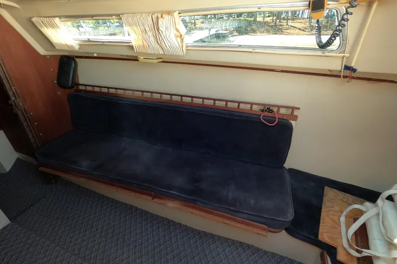 Slide: The Image of Interior of a 1983 Catalina 25 sailboat with blue cushioned seating. - 9
