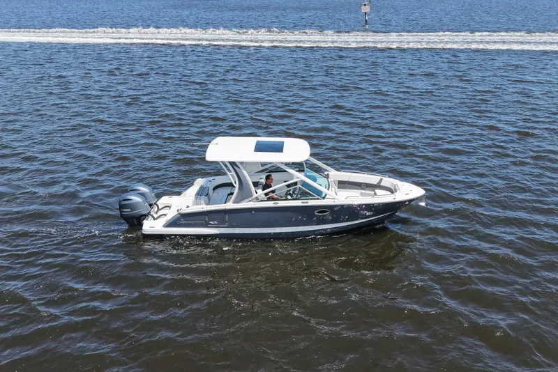 Slide: The Image of 2022 Chaparral 280 OSX boat cruising on open water with dual Yamaha engines. - 15