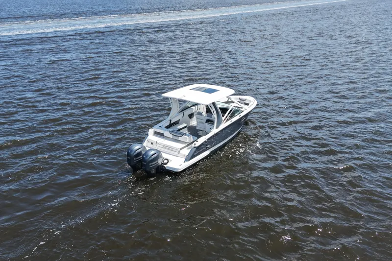 Slide: The Image of 2022 Chaparral 280 OSX boat cruising on open water with twin engines. - 16