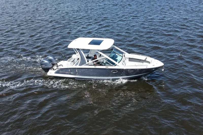 Slide: The Image of 2022 Chaparral 280 OSX boat cruising on open water, featuring dual outboard engines. - 2