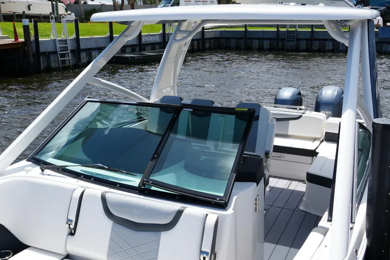 Slide: The Image of 2022 Chaparral 280 OSX boat with sleek design and dual engines docked by the water. - 20
