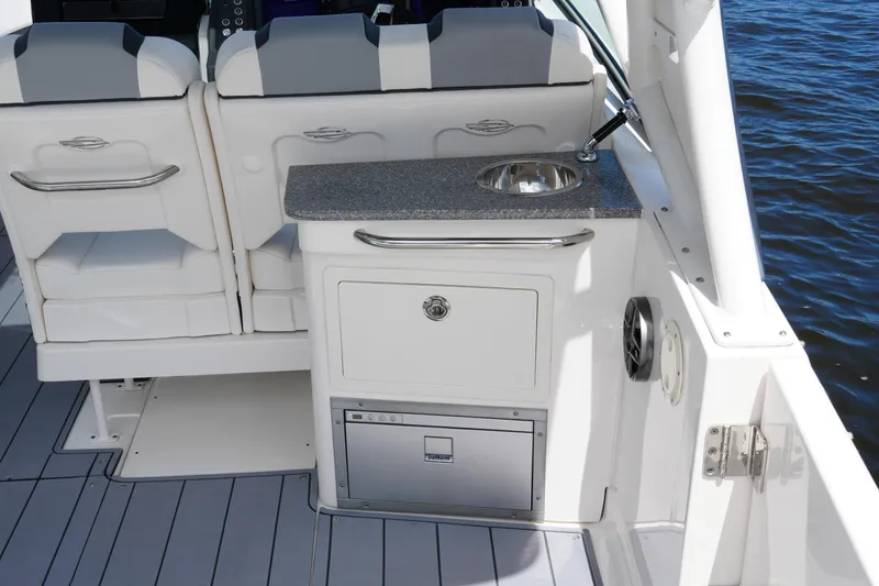 Slide: The Image of 2022 Chaparral 280 OSX boat interior with seating, sink, and storage. - 38